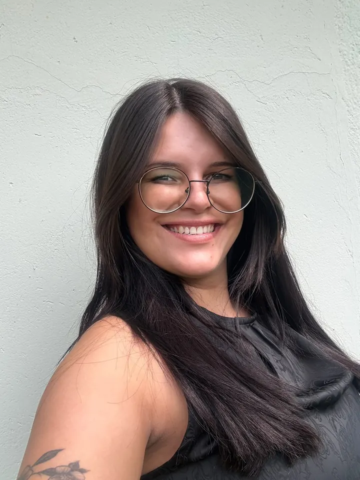 Vitória sorrindo, com seus cabelos longos e escuros